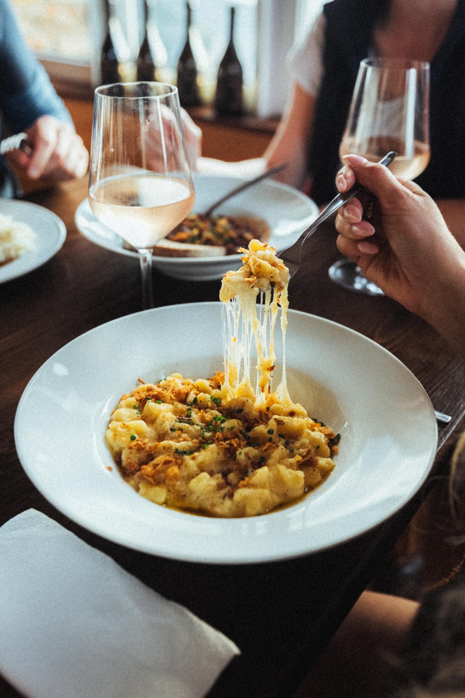 Käsespätzle mit Röstzwiebeln werden am Tisch genossen