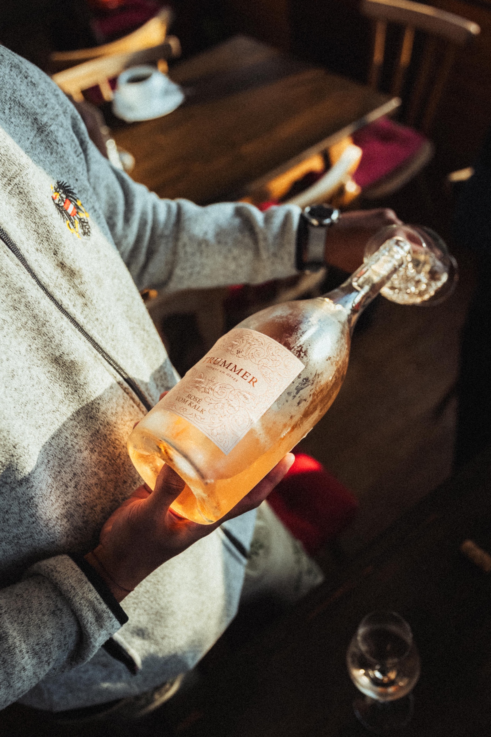 Flasche Roséwein wird in der Gaststube eingeschenkt